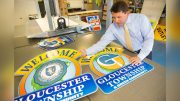 Gloucester Township Mayor David Mayer shown with the old and new township signs.